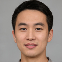 Joyful asian young-adult male with short  black hair and brown eyes