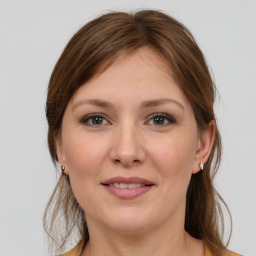 Joyful white young-adult female with long  brown hair and grey eyes