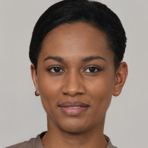 Joyful black young-adult female with short  black hair and brown eyes
