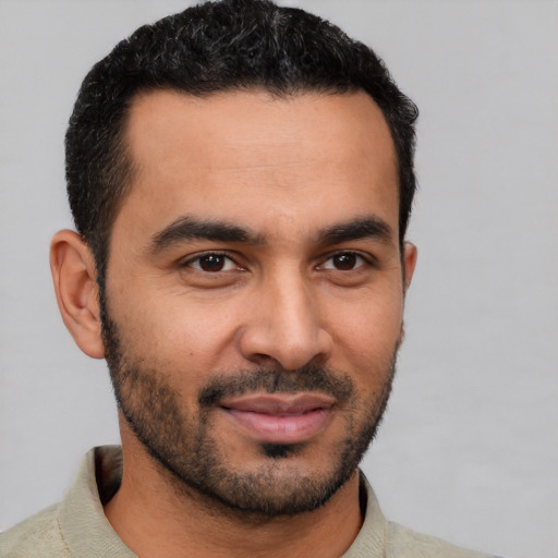 Joyful latino young-adult male with short  black hair and brown eyes
