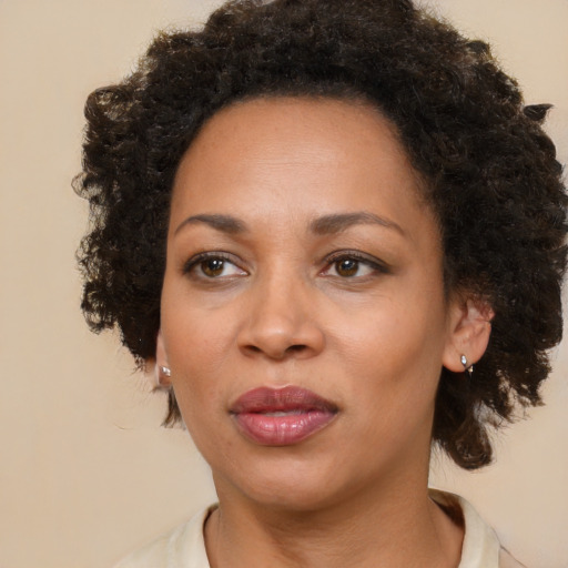 Joyful black adult female with medium  brown hair and brown eyes