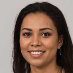 Joyful latino young-adult female with long  brown hair and brown eyes