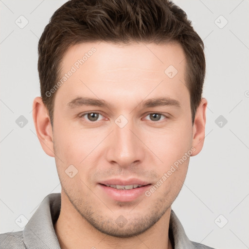 Joyful white young-adult male with short  brown hair and grey eyes