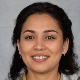 Joyful latino young-adult female with medium  brown hair and brown eyes