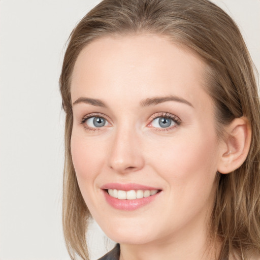 Joyful white young-adult female with long  brown hair and blue eyes