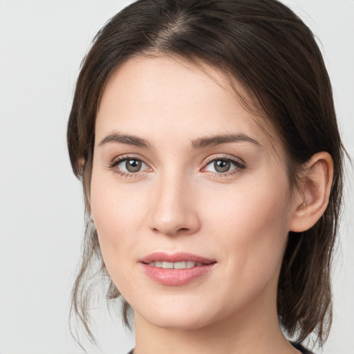 Joyful white young-adult female with medium  brown hair and grey eyes