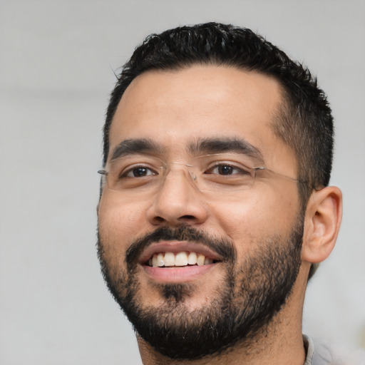 Joyful latino young-adult male with short  black hair and brown eyes