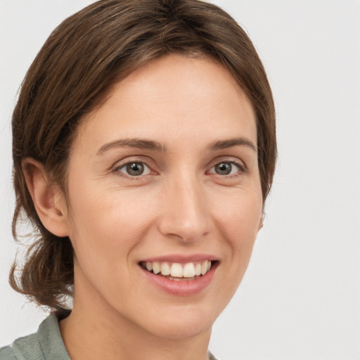 Joyful white young-adult female with medium  brown hair and grey eyes