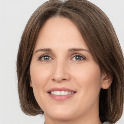 Joyful white young-adult female with medium  brown hair and green eyes