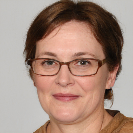 Joyful white adult female with medium  brown hair and blue eyes