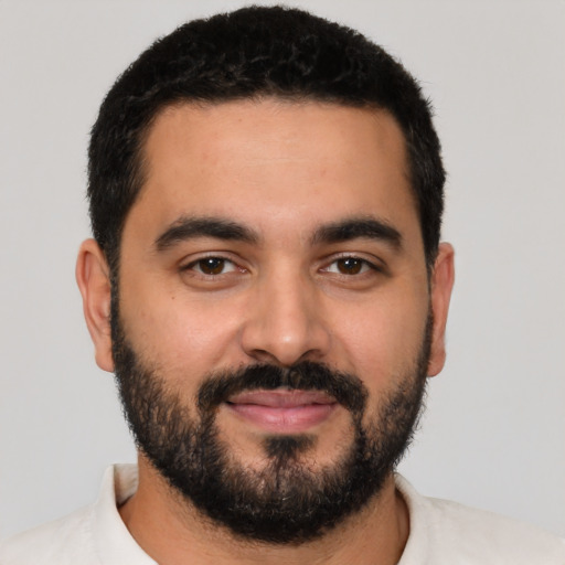 Joyful latino young-adult male with short  black hair and brown eyes