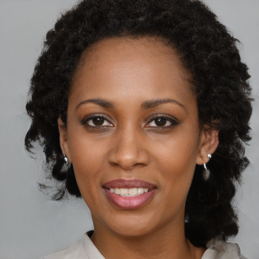 Joyful black young-adult female with medium  brown hair and brown eyes