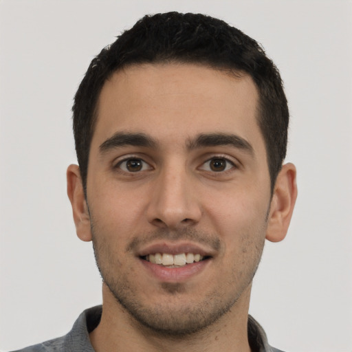 Joyful white young-adult male with short  black hair and brown eyes