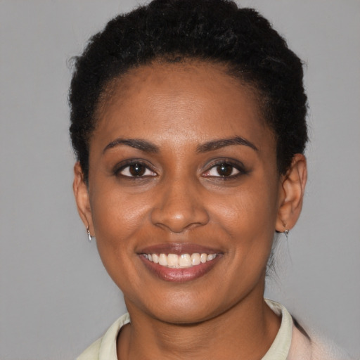 Joyful black young-adult female with short  brown hair and brown eyes