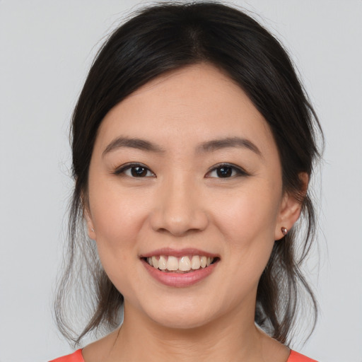 Joyful asian young-adult female with medium  brown hair and brown eyes