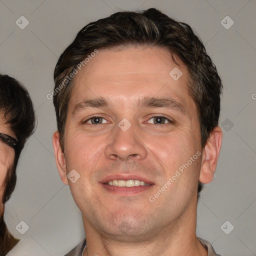 Joyful white adult male with short  brown hair and brown eyes