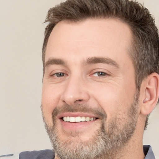 Joyful white adult male with short  brown hair and brown eyes