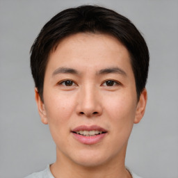 Joyful asian young-adult male with short  brown hair and brown eyes