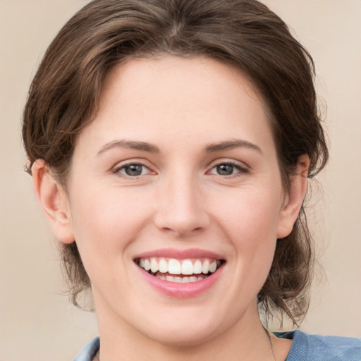 Joyful white young-adult female with medium  brown hair and green eyes