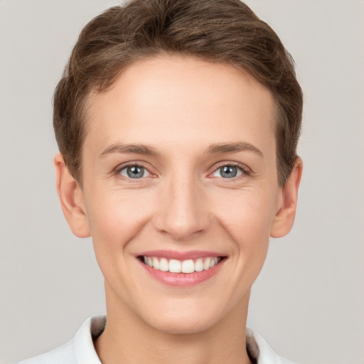 Joyful white young-adult female with short  brown hair and grey eyes