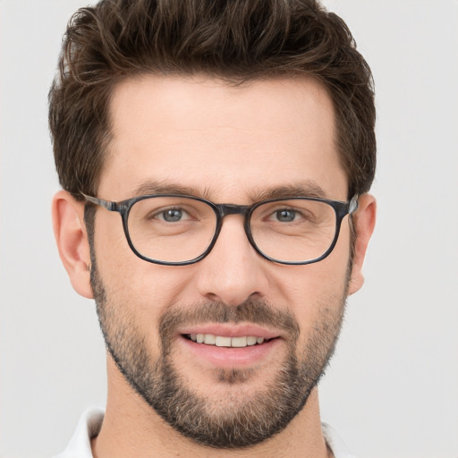 Joyful white young-adult male with short  brown hair and grey eyes