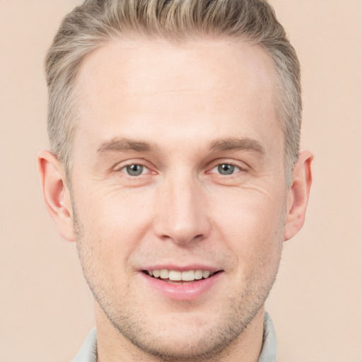 Joyful white young-adult male with short  brown hair and grey eyes