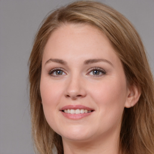 Joyful white young-adult female with long  brown hair and blue eyes