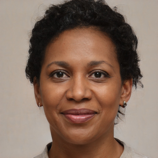 Joyful black adult female with medium  brown hair and brown eyes