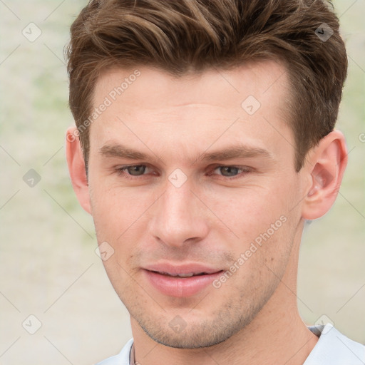 Joyful white young-adult male with short  brown hair and grey eyes