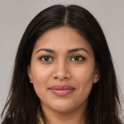 Joyful latino young-adult female with long  brown hair and brown eyes