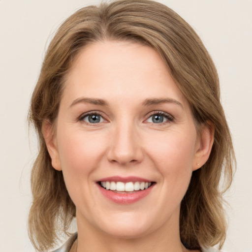 Joyful white young-adult female with medium  brown hair and green eyes