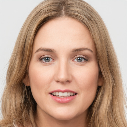 Joyful white young-adult female with long  brown hair and green eyes