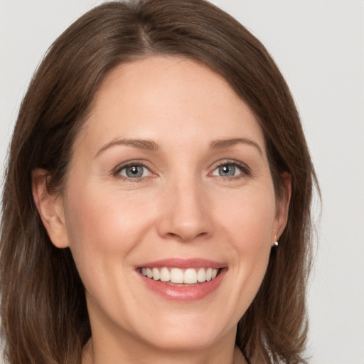 Joyful white adult female with medium  brown hair and grey eyes