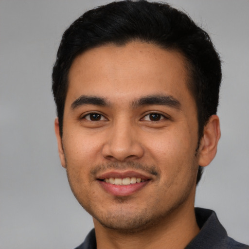 Joyful latino young-adult male with short  black hair and brown eyes