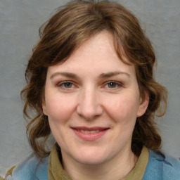 Joyful white young-adult female with medium  brown hair and blue eyes