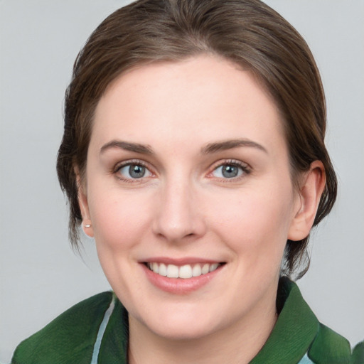 Joyful white young-adult female with medium  brown hair and green eyes