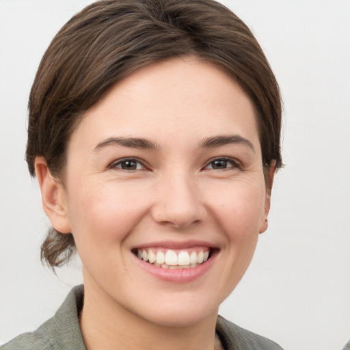 Joyful white young-adult female with short  brown hair and grey eyes