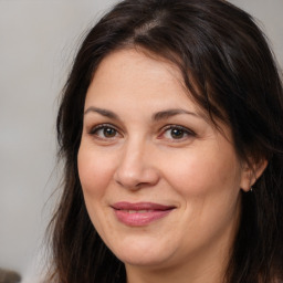 Joyful white adult female with long  brown hair and brown eyes