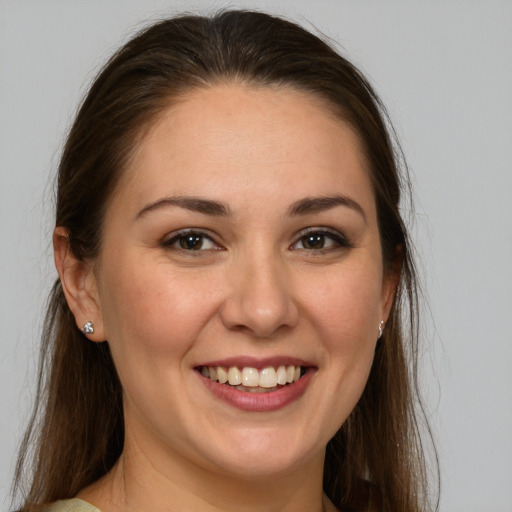 Joyful white young-adult female with long  brown hair and brown eyes