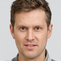 Joyful white adult male with short  brown hair and grey eyes