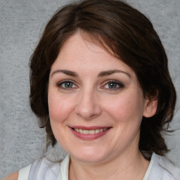 Joyful white adult female with medium  brown hair and blue eyes