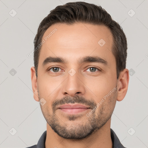 Joyful white young-adult male with short  black hair and brown eyes