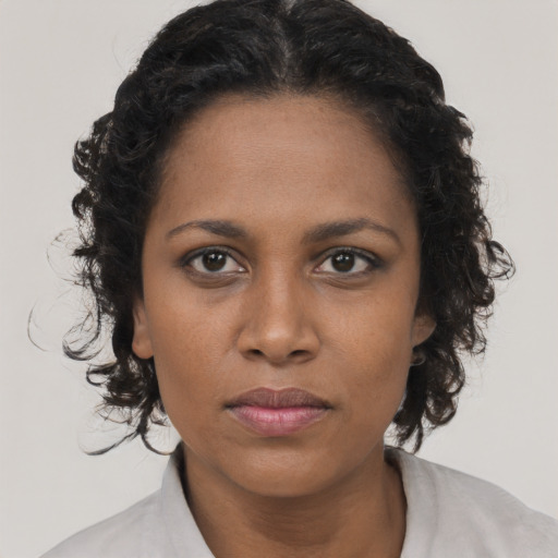 Joyful black young-adult female with medium  brown hair and brown eyes