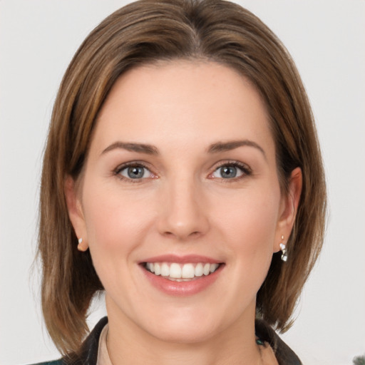 Joyful white young-adult female with medium  brown hair and grey eyes