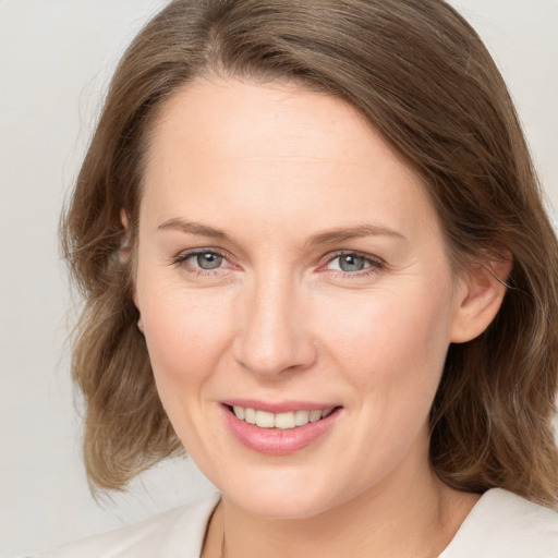 Joyful white adult female with medium  brown hair and grey eyes