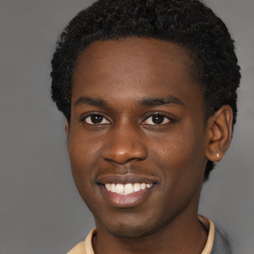 Joyful black young-adult male with short  brown hair and brown eyes