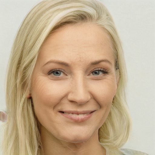 Joyful white adult female with long  blond hair and blue eyes