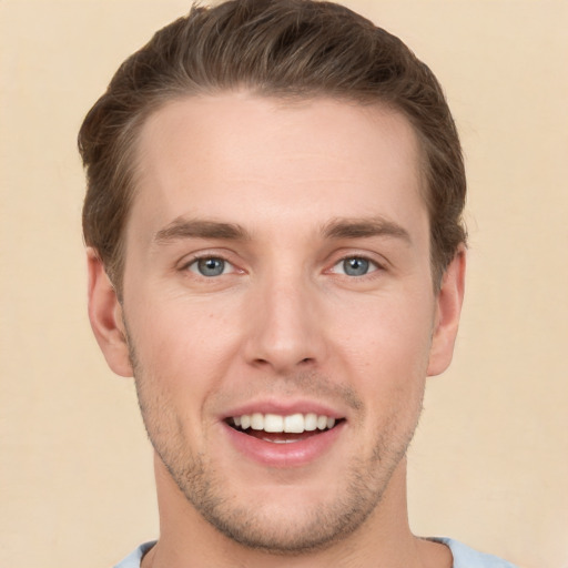 Joyful white young-adult male with short  brown hair and grey eyes