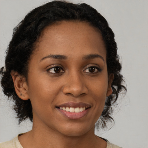 Joyful black young-adult female with long  brown hair and brown eyes