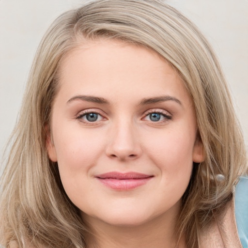 Joyful white young-adult female with long  brown hair and blue eyes